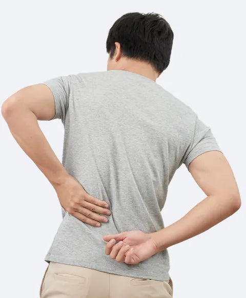 A man seen from behind, both hands on his lower back