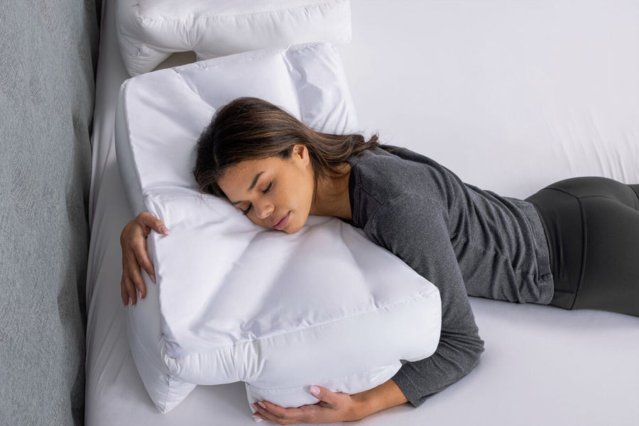 A side sleeper on the Wife Pillow in a bedroom